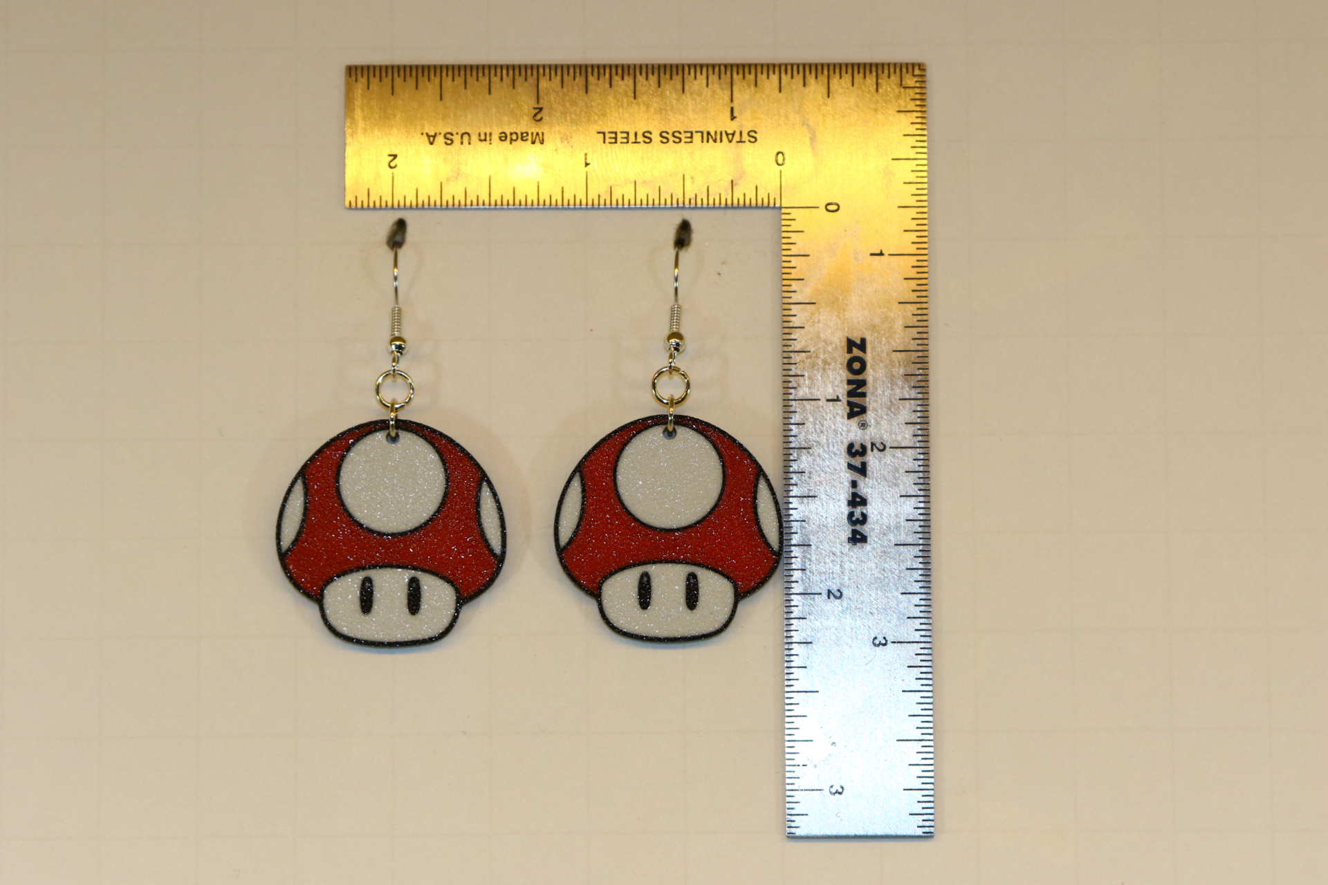 Pair of red and white Mario power-up mushroom earrings.