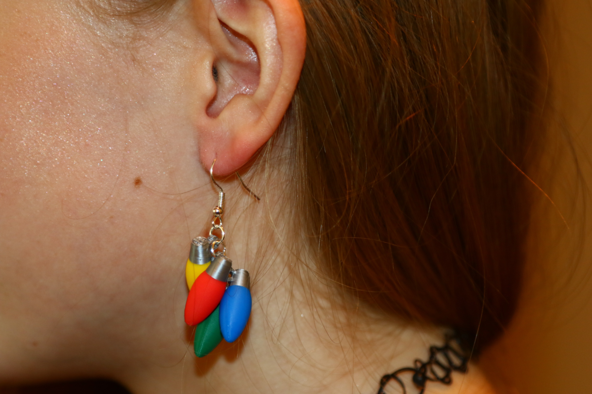 Pair of colorful Christmas light bulb earrings in red, green, and yellow.