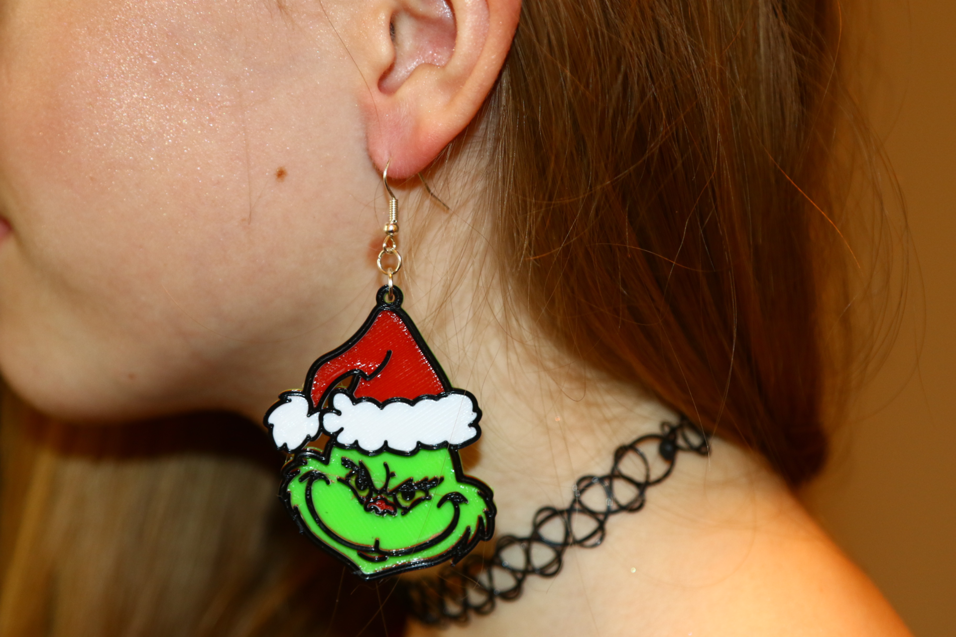 Pair of Grinch earrings with green and red accents.