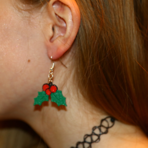 Pair of holly berry earrings with green leaves and red berries.