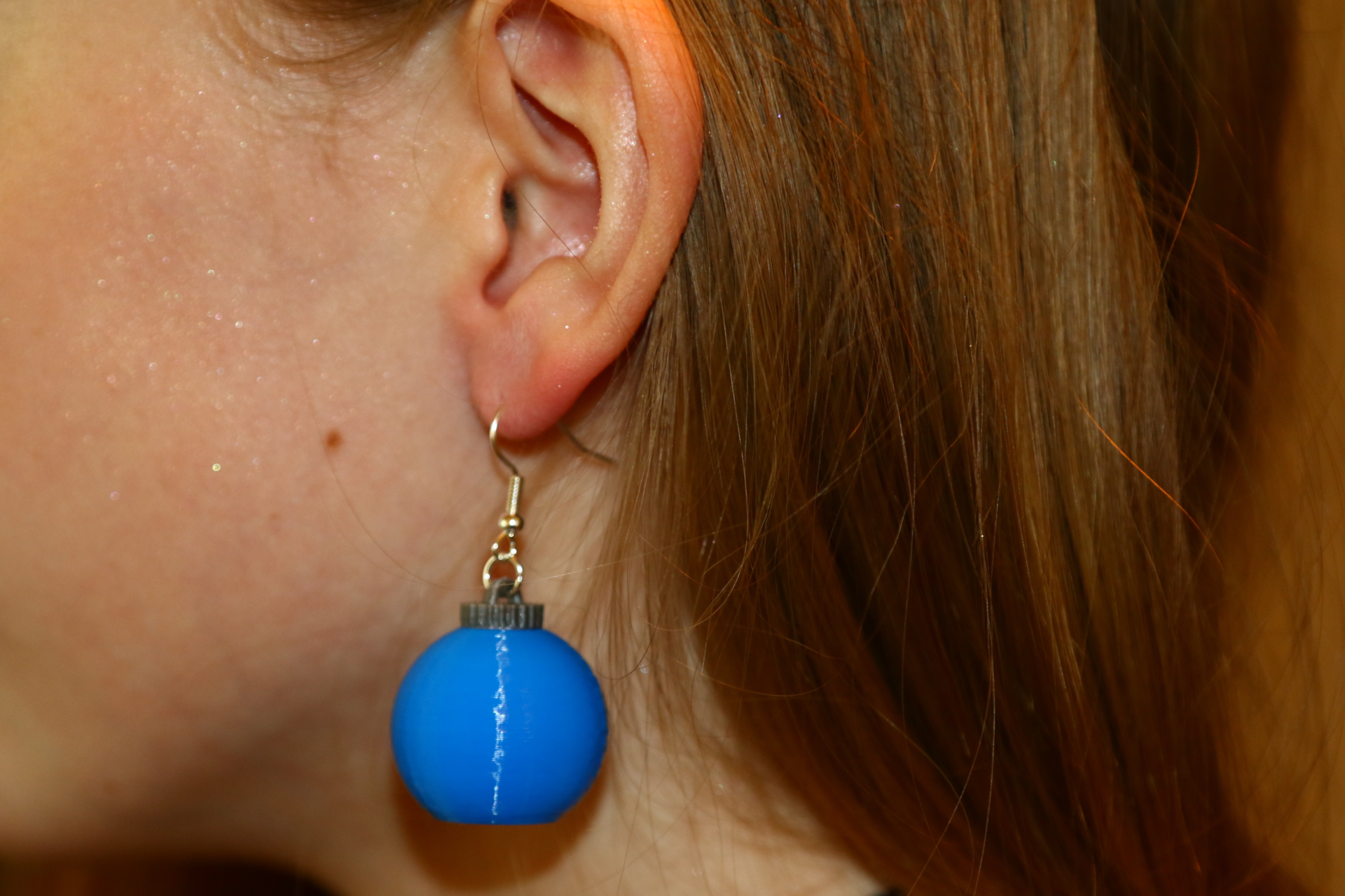 Pair of Christmas ornament earrings with red and green details.
