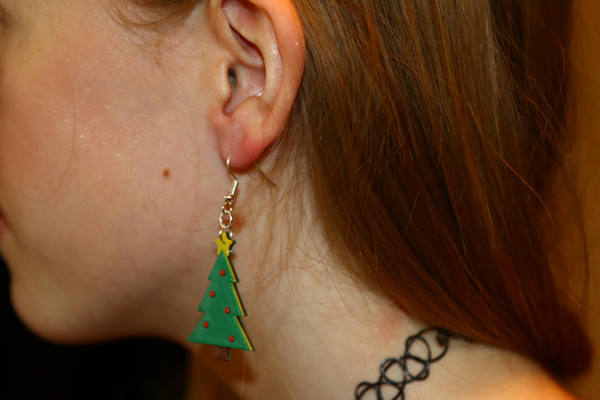Pair of green Christmas tree earrings with ornament details.