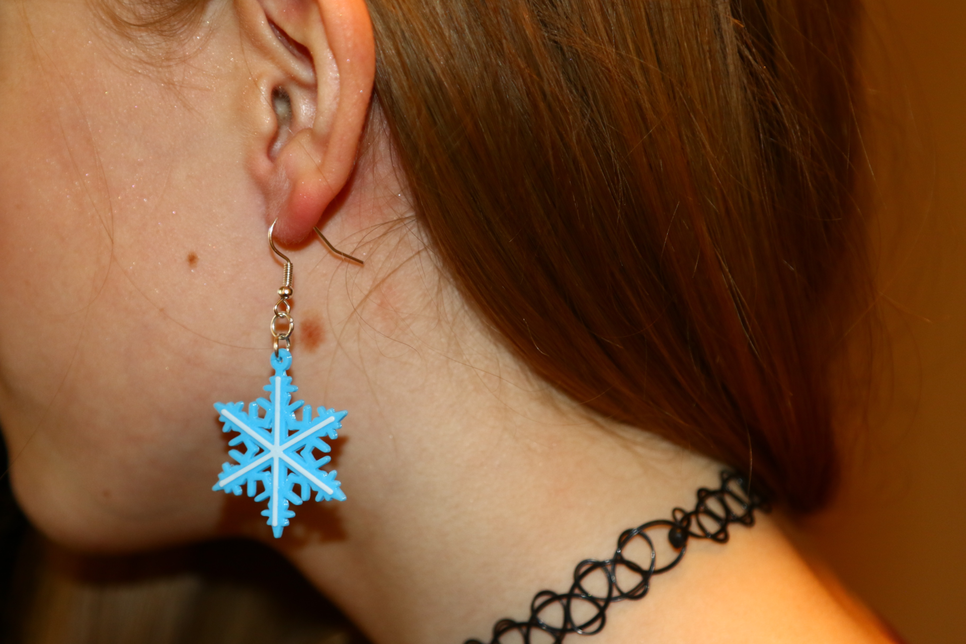 Pair of silver snowflake Christmas earrings with intricate detailing.