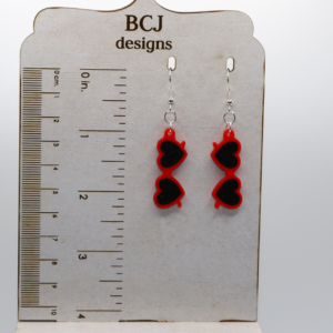 Pair of heart-shaped sunglasses earrings in bright red with silver hooks.