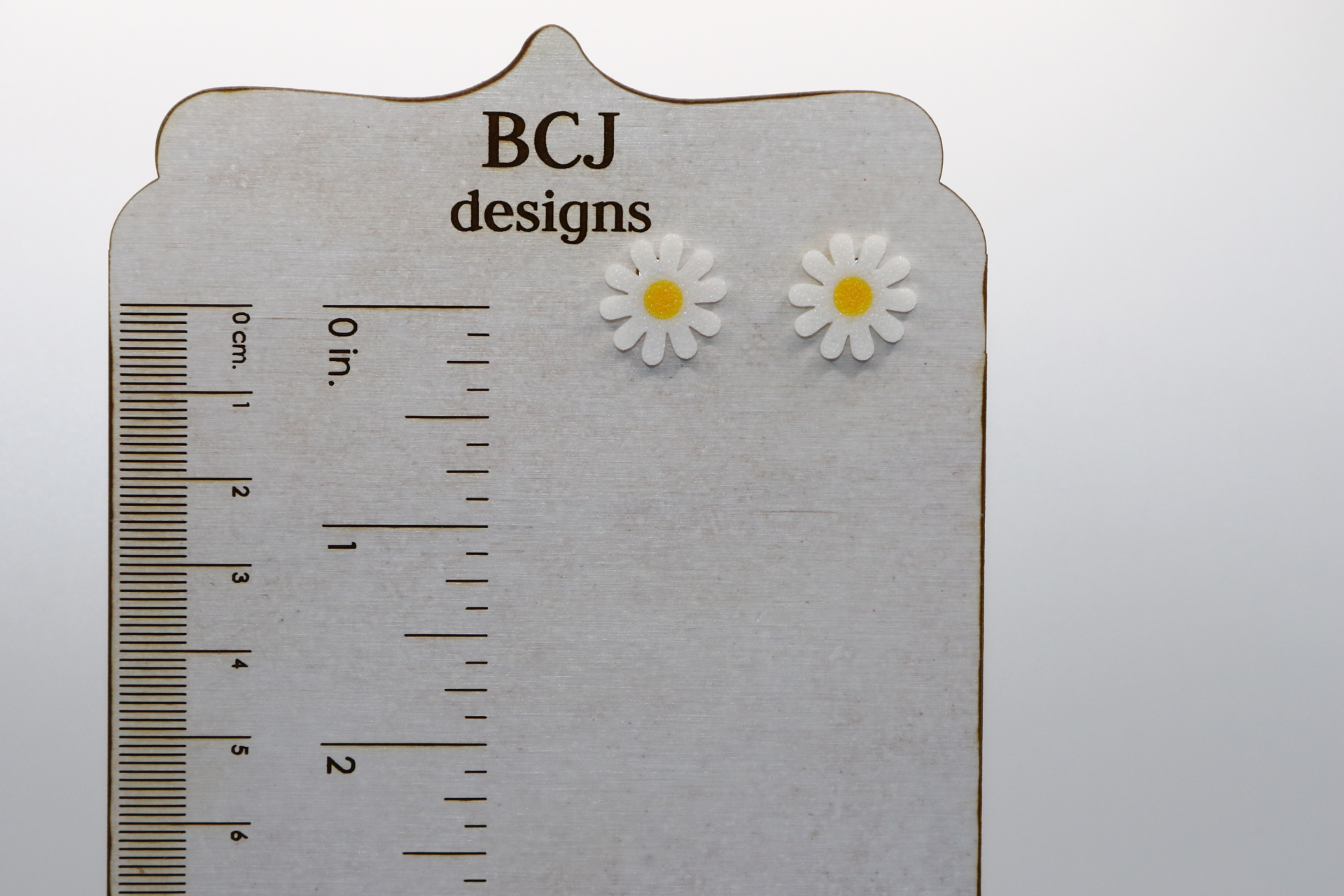 Daisy stud earrings with detailed petals and cheerful design.