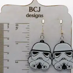 Pair of white Stormtrooper helmet earrings with black detailing.