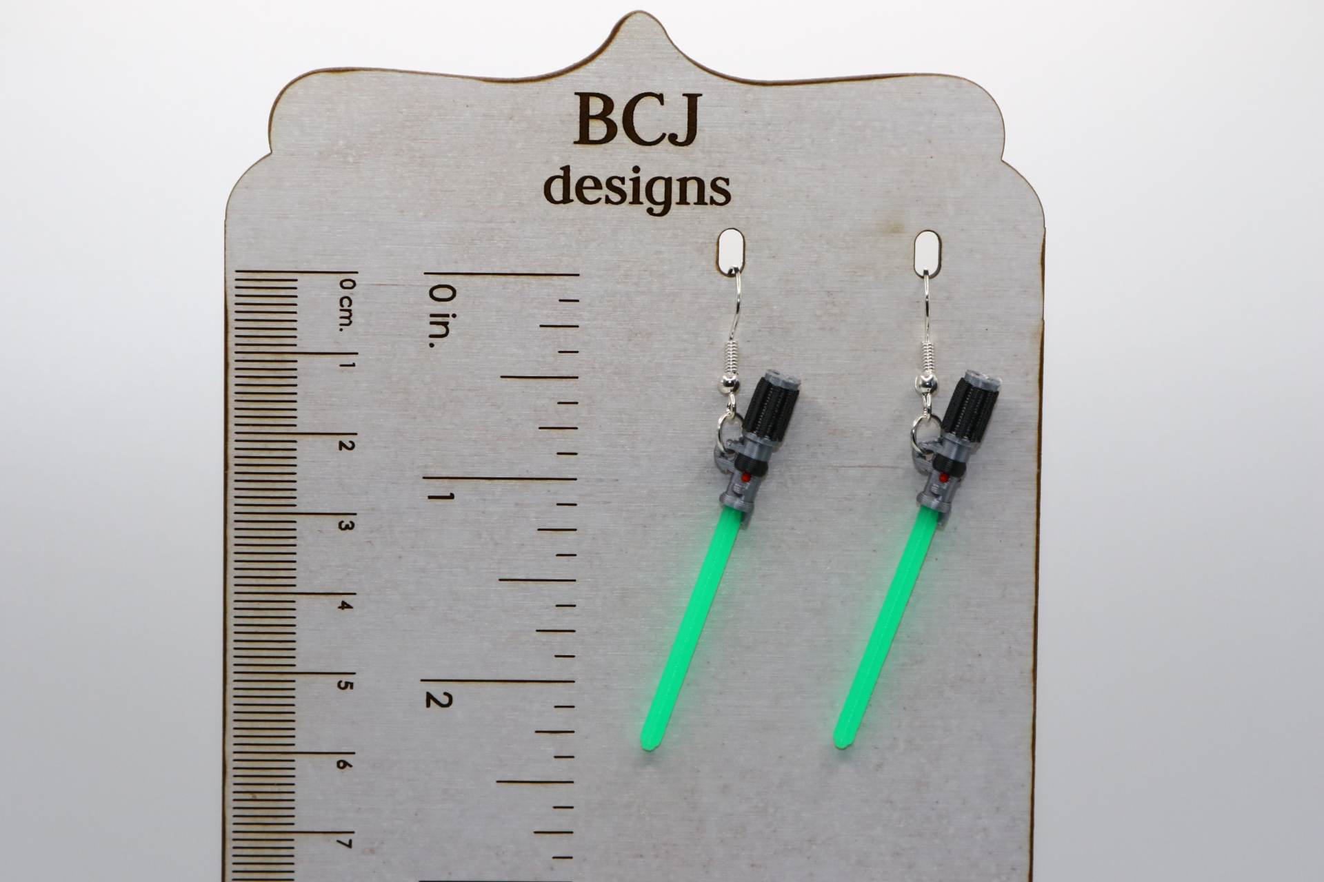 Pair of colorful lightsaber earrings with silver hooks.