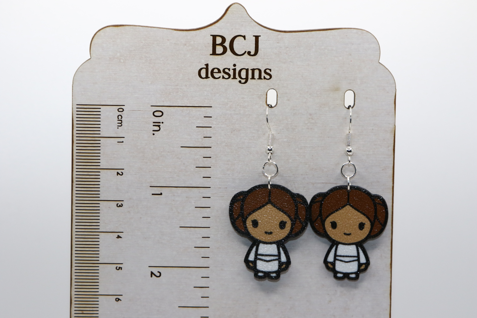 Princess Leia earrings with brown hair bun design.