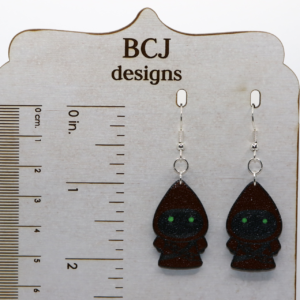 Pair of earrings shaped like small hooded Jawas with glowing yellow eyes.