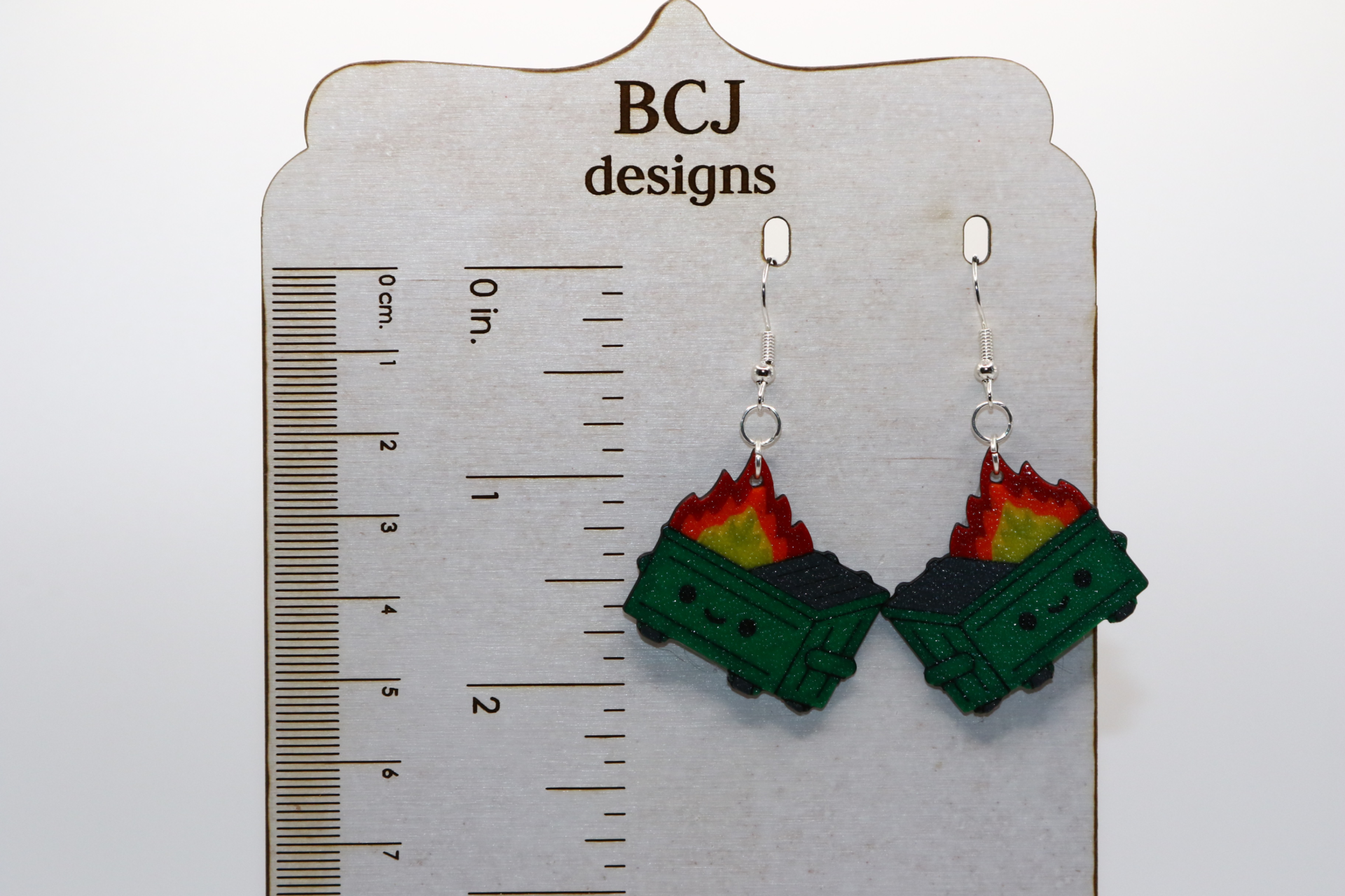 Bright dumpster fire earrings showing a flaming trash bin.