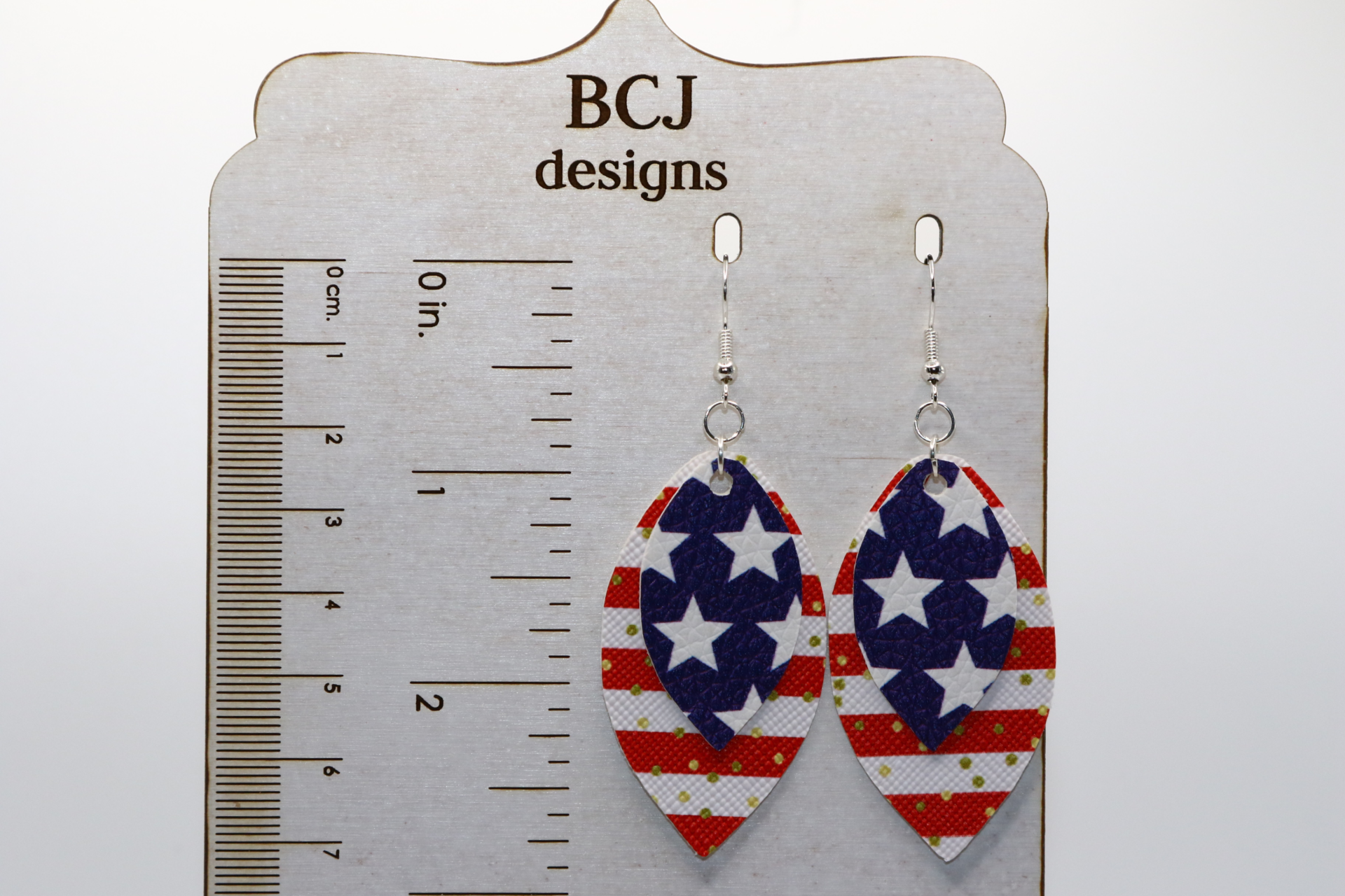 Pair of faux leather star earrings in red, white, and blue pattern.