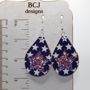 Pair of glittery red, white, and blue star earrings with silver hooks.