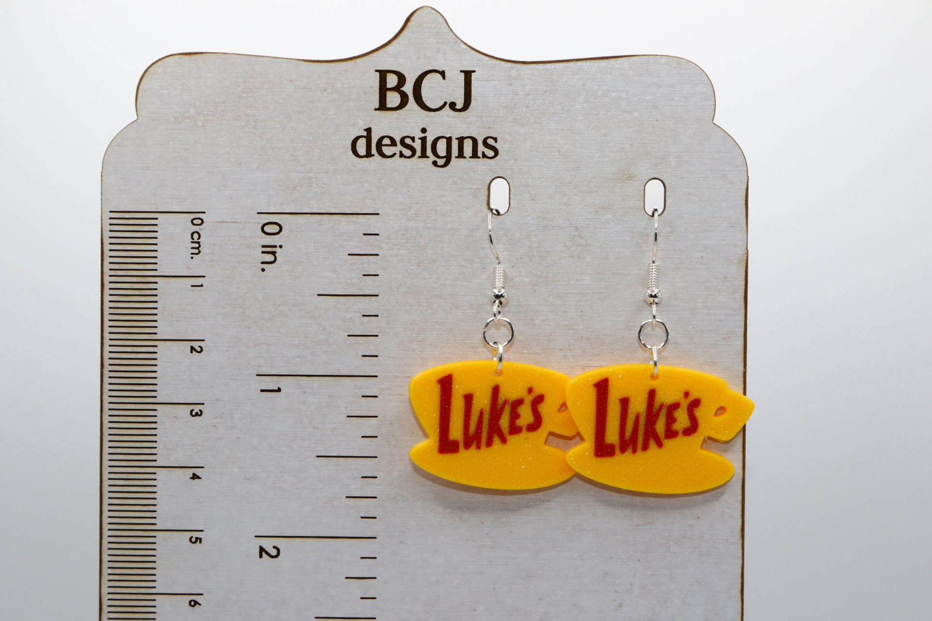 Luke’s diner coffee cup logo earrings in yellow.
