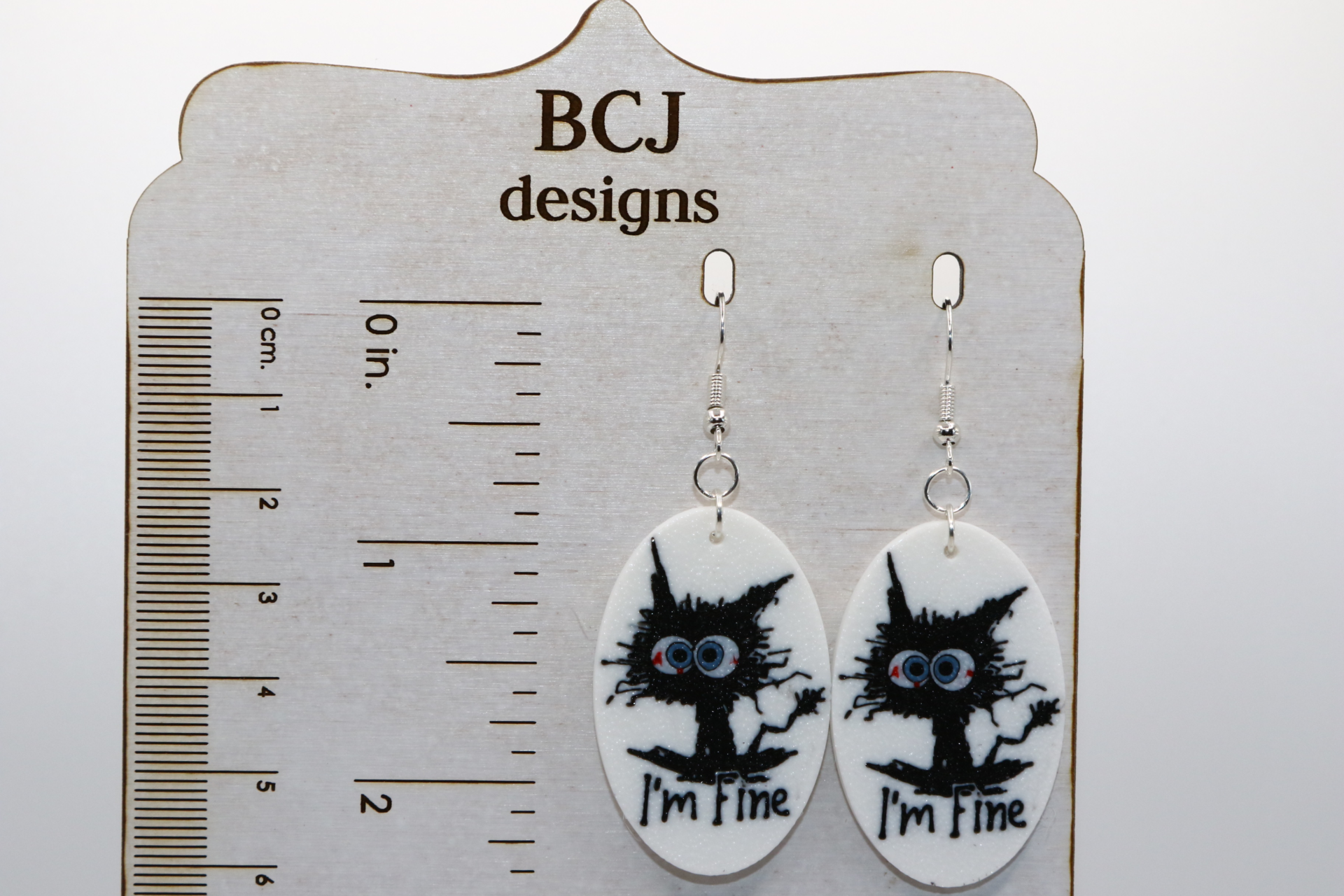 Pair of “I’m Fine” cat earrings showing a cartoon cat on fire.