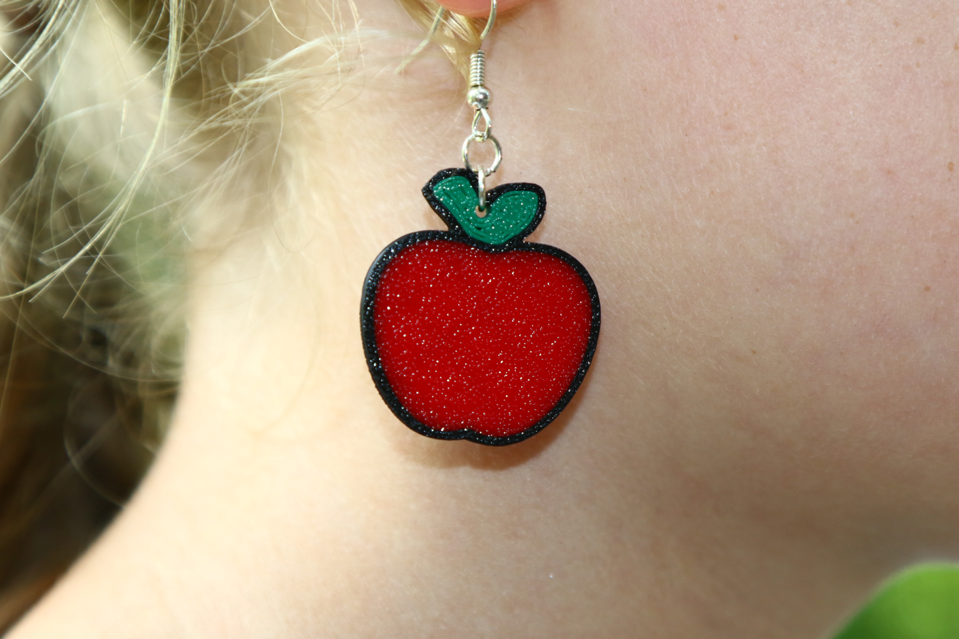 Pair of earrings shaped like a bright red apple with a green leaf.
