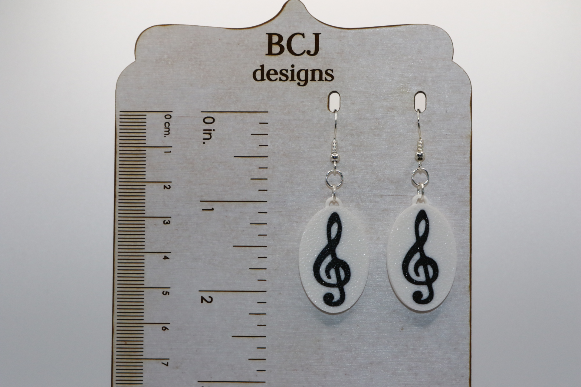 Set of earrings featuring treble, bass, alto, and tenor clef designs in a smooth silver finish.