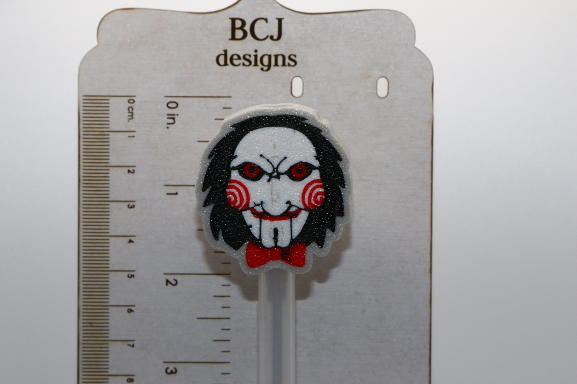 Jigsaw straw topper featuring detailed puppet face design.