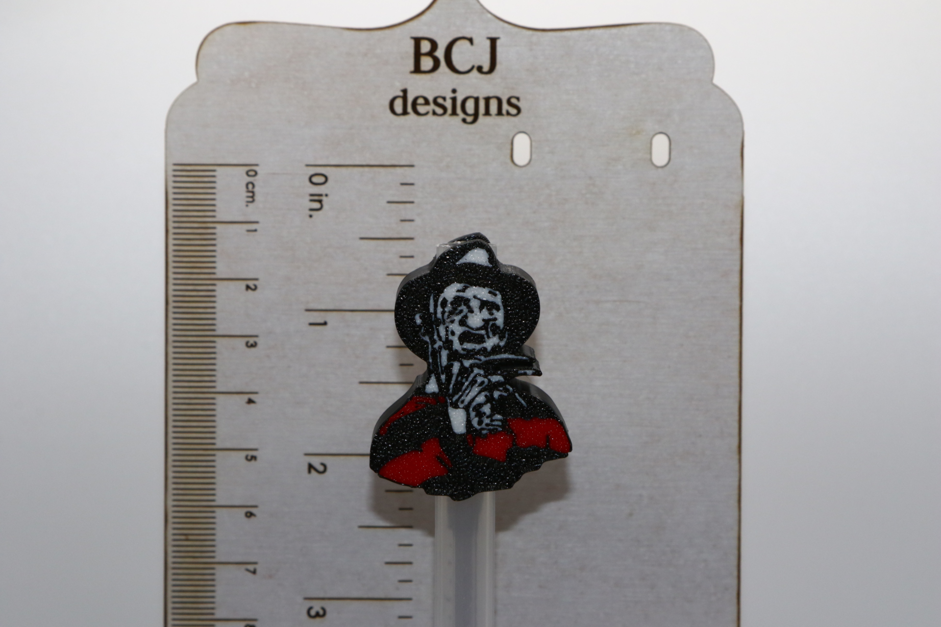 Freddy Krueger straw topper with red and green striped design.