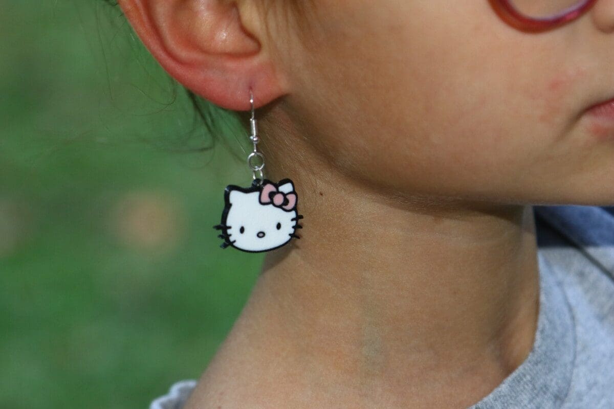 Hello Kitty earrings with red bow and white face design.