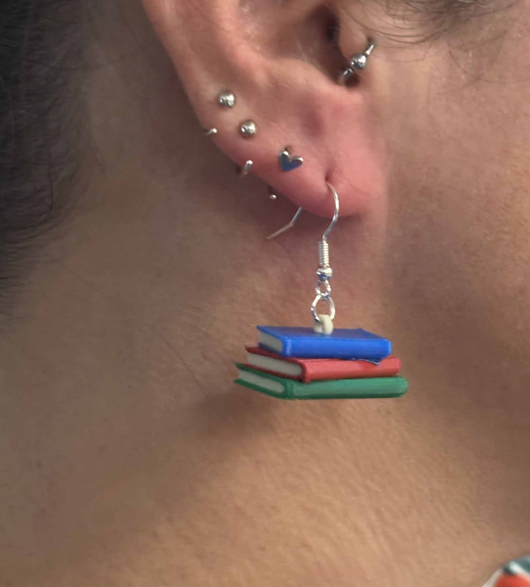 Pair of earrings featuring a stack of colorful books with detailed spines.