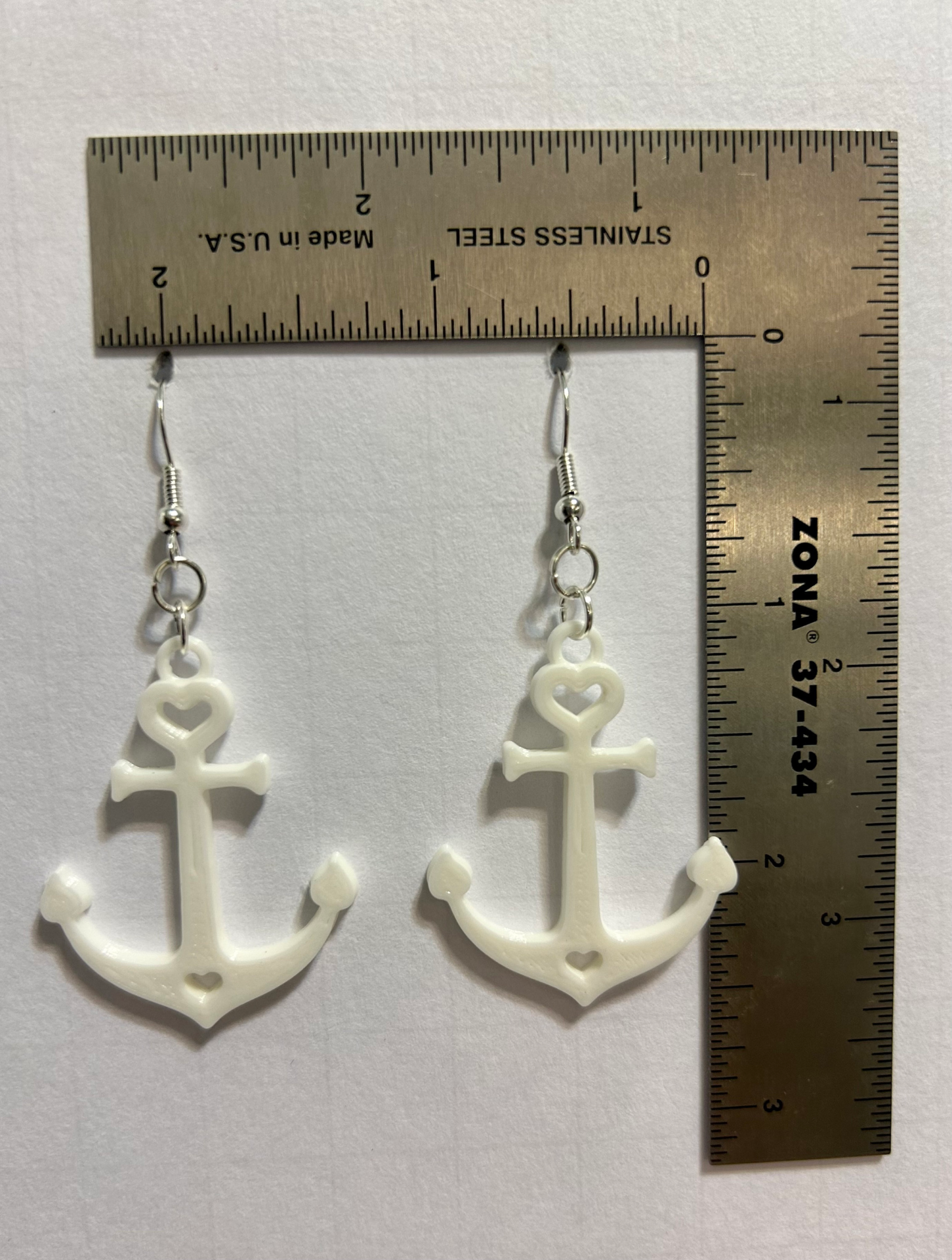 Pair of silver anchor-shaped earrings with small loop details.