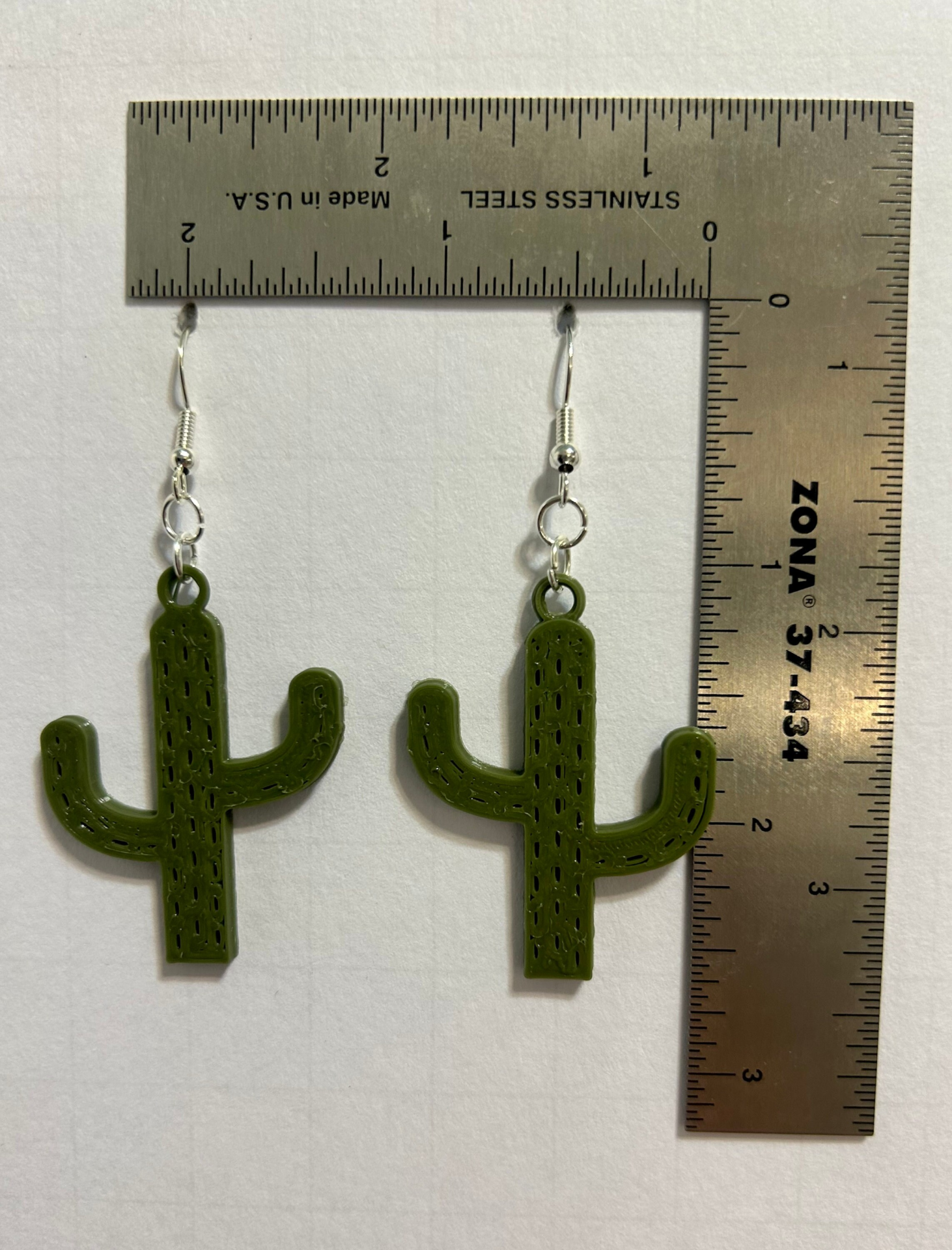 Green cactus-shaped earrings, festive Cinco de Mayo accessory.