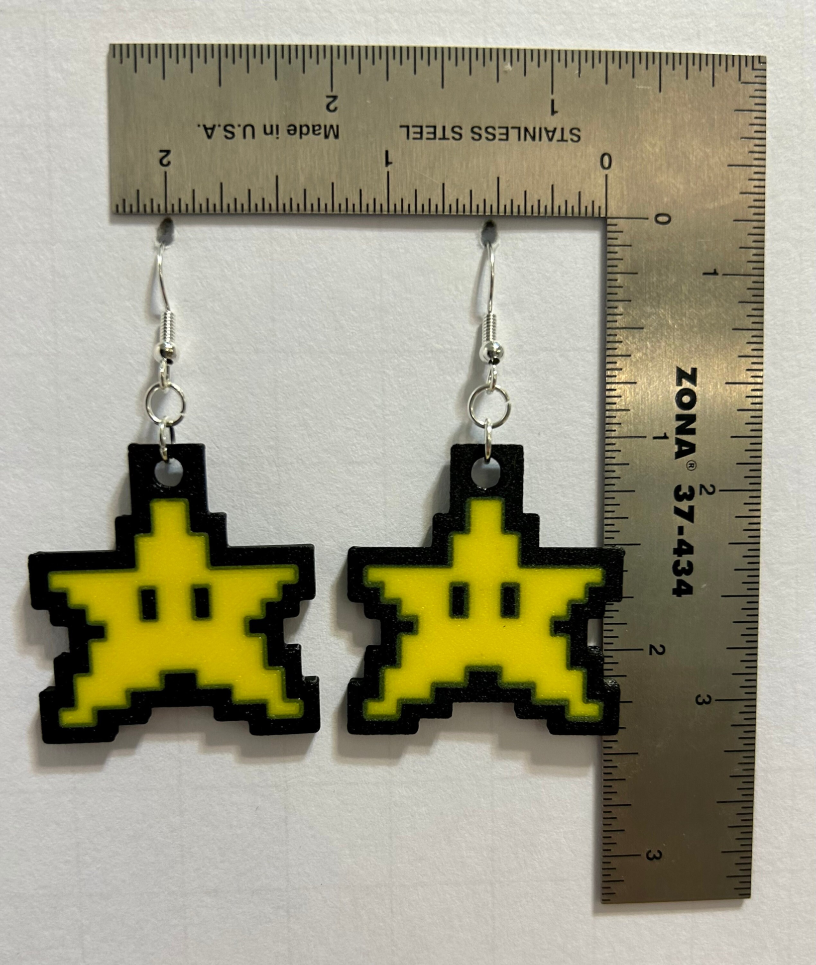 Pair of yellow pixelated Mario star earrings with silver hooks