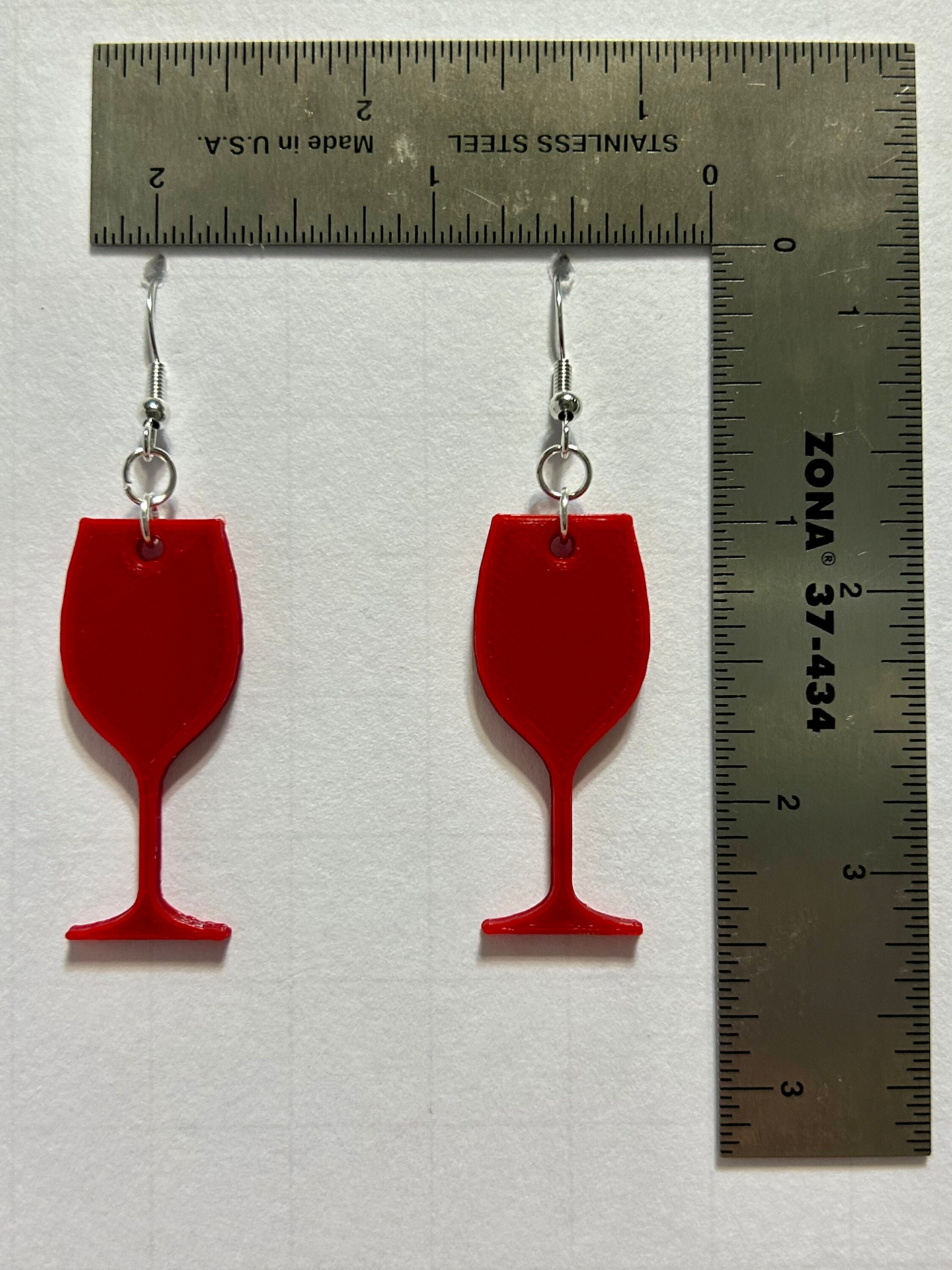 Wine glass earrings with detailed beverage design.