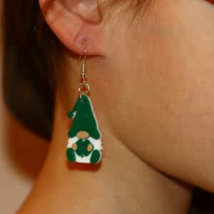 Gnome earrings holding a bright green four-leaf clover, festive St. Patrick’s Day design