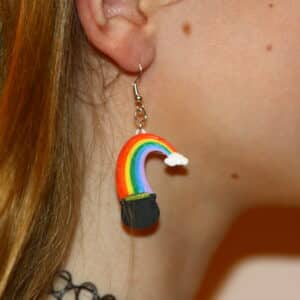 Earrings featuring rainbow arching into a pot of gold, festive St. Patrick’s Day design